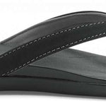 Olukai Ladies Ho'opio Sandals 2022 - A pair of black sandals with a strap that goes between the big and second toe, featuring a small heel.