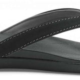 Olukai Ladies Ho'opio Sandals 2022 - A pair of black sandals with a strap that goes between the big and second toe, featuring a small heel.