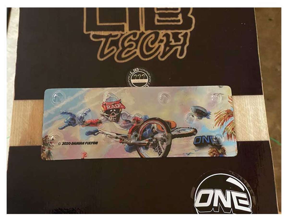 Oneball Radical Rick Stomp Pad - A black stomp pad with a cartoon image of a man wearing a red and white striped shirt, blue jeans, and sunglasses riding a skateboard on it.