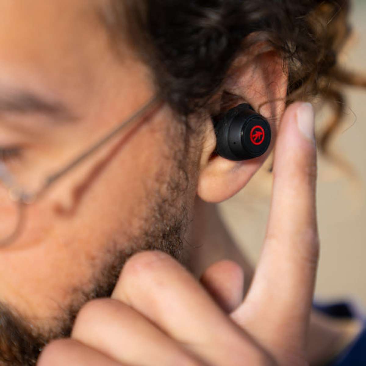 Outdoor Tech Pearls Wireless Earbuds - A pair of black wireless earbuds with a red logo on each bud.