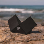 Outdoor Tech Twin Peaks Portable Speaker - Black speaker with white logo on front, angled to show side and top.