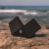 Outdoor Tech Twin Peaks Portable Speaker - Black speaker with white logo on front, angled to show side and top.