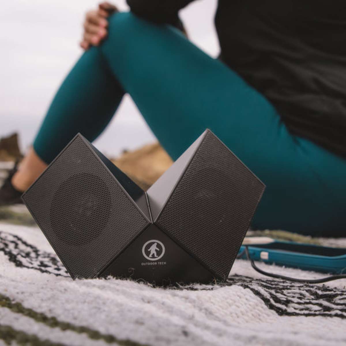 Outdoor Tech Twin Peaks Portable Speaker - A black portable speaker with a mesh grille and two speakers on either side of the top, angled slightly outward.