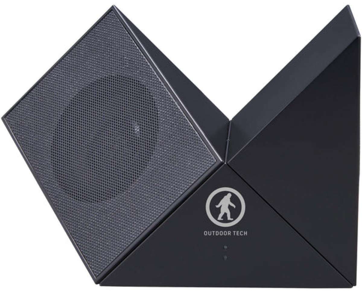 Outdoor Tech Twin Peaks Portable Speaker - A black portable speaker with a mesh front and a circular logo featuring a mountain peak design.