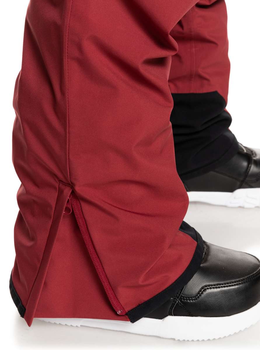 Quiksilver Utility Shell Pant 2023 - A pair of red snow pants with black trim and a zippered pocket on the side.