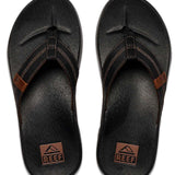 Reef Cushion Phantom LE Sandal 2022 - A pair of black sandals with a strap that goes between the big and second toe, featuring a brown logo on the strap.