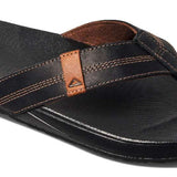 Reef Cushion Phantom LE Sandal 2022 - A black sandal with a brown logo on the strap and a textured footbed.
