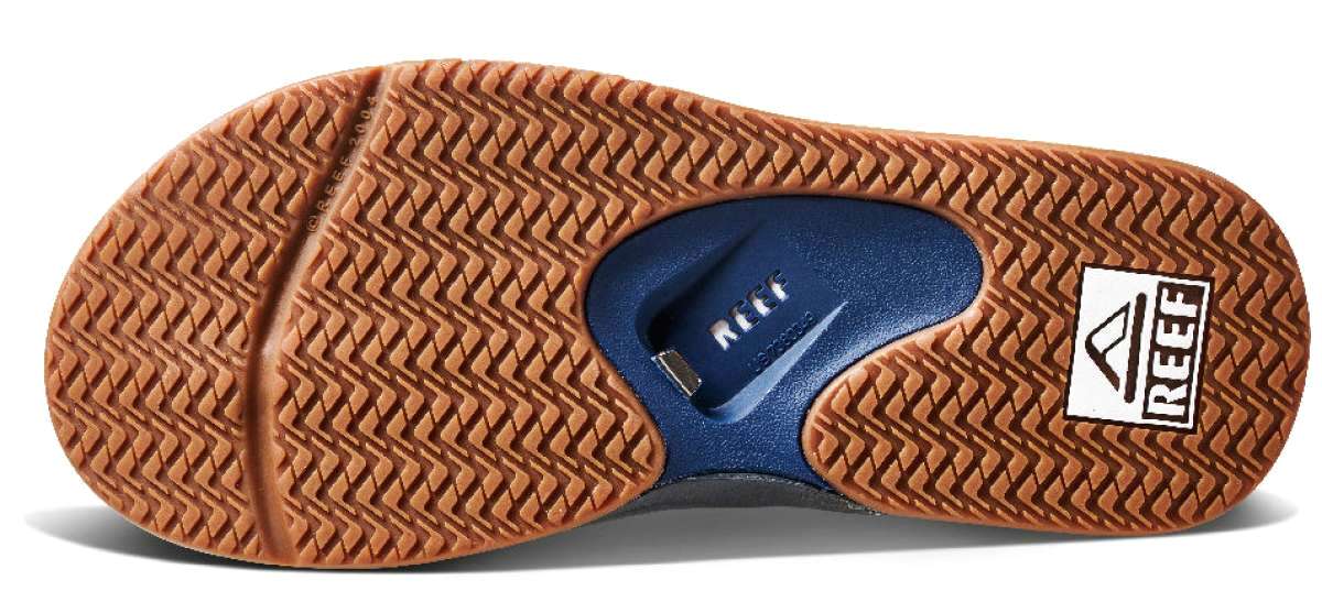 Reef Men's Fanning Sandal - A pair of brown sandals with a thick sole and a strap that goes between the big and second toe.