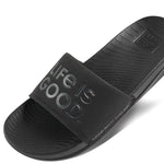 Reef X Life Is Good Women's Slide 2022 - A pair of black slide sandals with a logo on the strap.