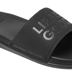 Reef X Life Is Good Women's Slide 2022 - A black slide sandal with a logo on the strap and a textured footbed.