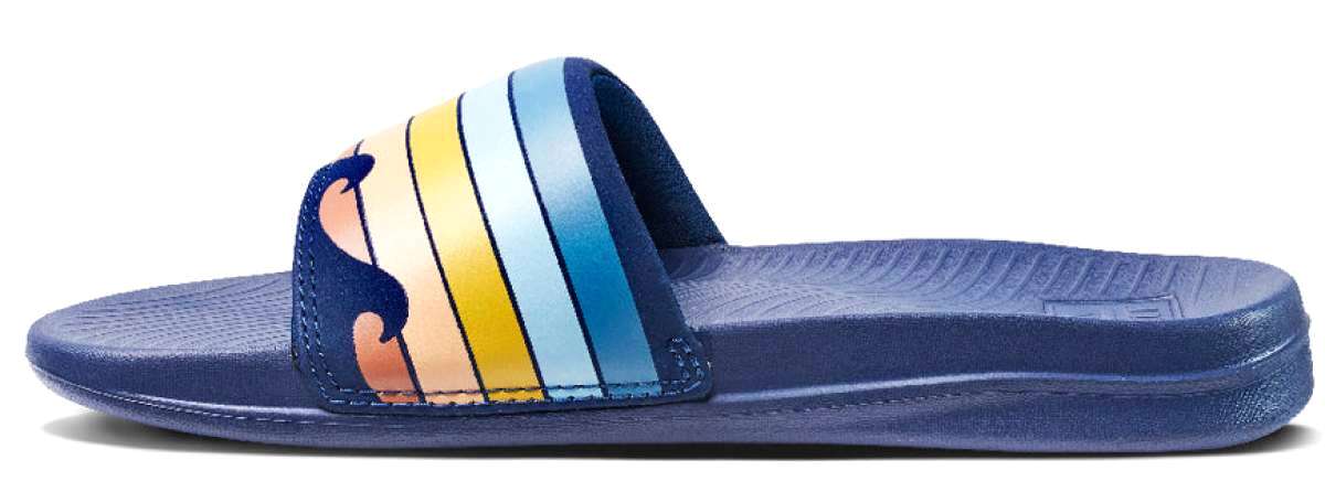 Reef X Life Is Good Women's Slide 2022 - A pair of women's slides with a blue sole and strap, featuring a wave logo on the side in shades of orange and yellow.
