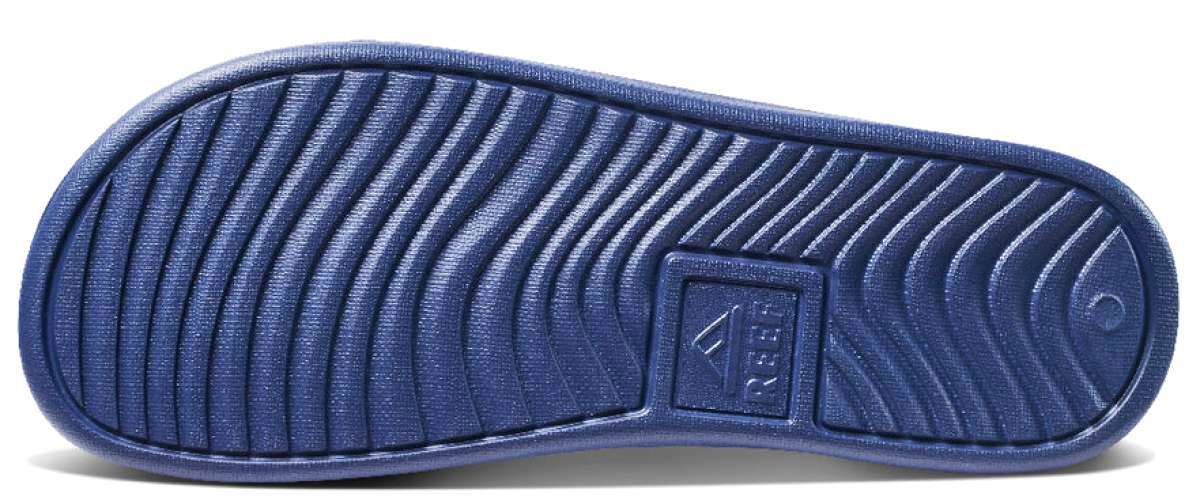 Reef X Life Is Good Women's Slide 2022 - A blue slide sandal with a textured strap and a logo on the side.