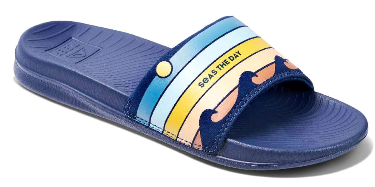 Reef X Life Is Good Women's Slide 2022 - A pair of blue slide sandals with a logo on the strap.