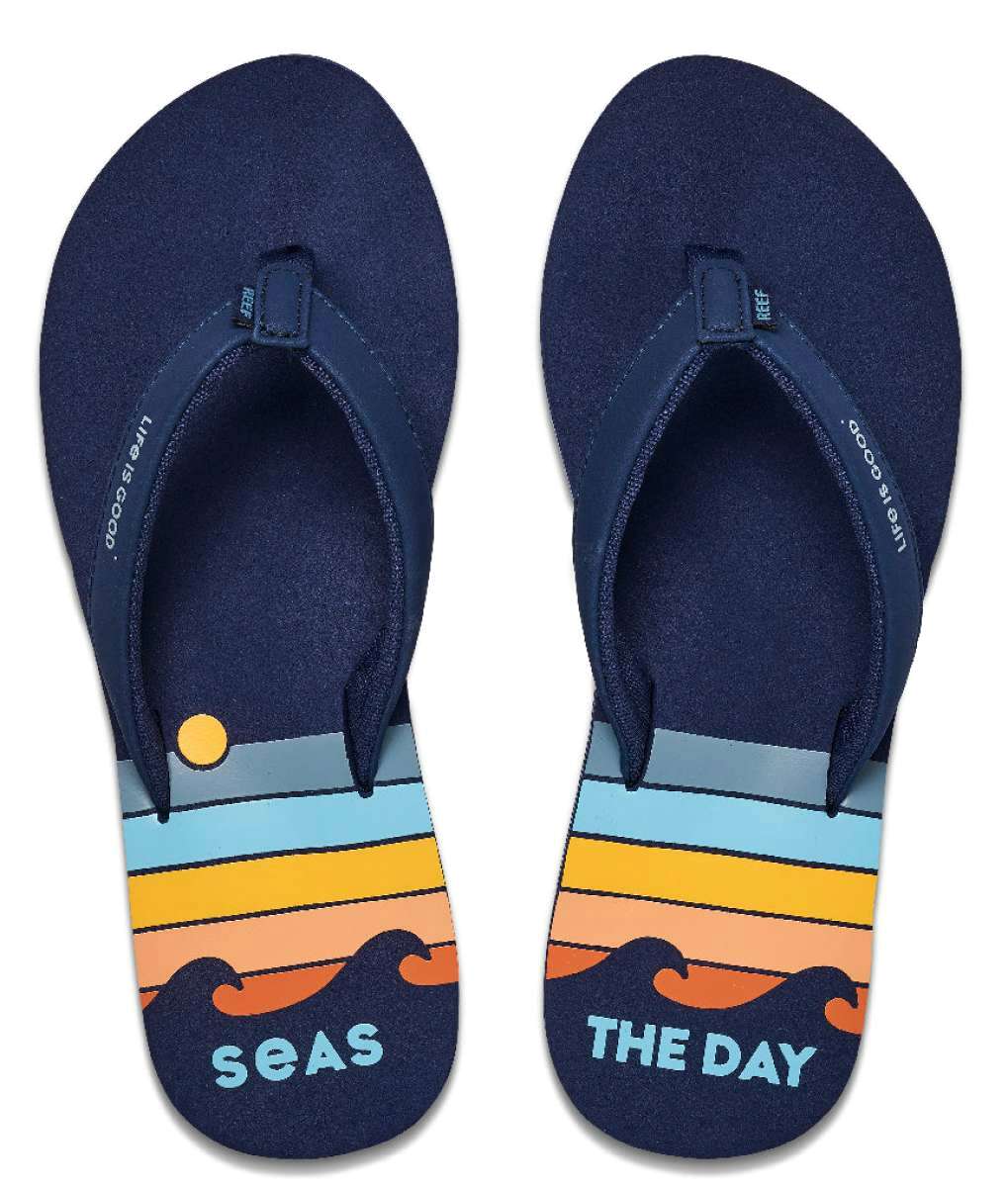 Reef Women's X Life Is Good Sandal - A pair of navy blue sandals with a yellow logo on the strap.