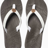Reef Women's Zen Love Sandal 2020 - A pair of women's sandals with a tan strap and a brown logo on top, featuring a wave pattern on the sole.