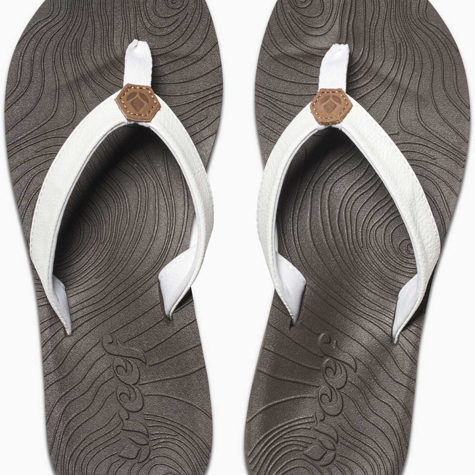 Reef Women's Zen Love Sandal 2020 - A pair of women's sandals with a tan strap and a brown logo on top, featuring a wave pattern on the sole.
