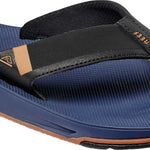 Reef Men's Fanning Low Sandal - A blue sandal with a brown logo on the strap and a clear sole.