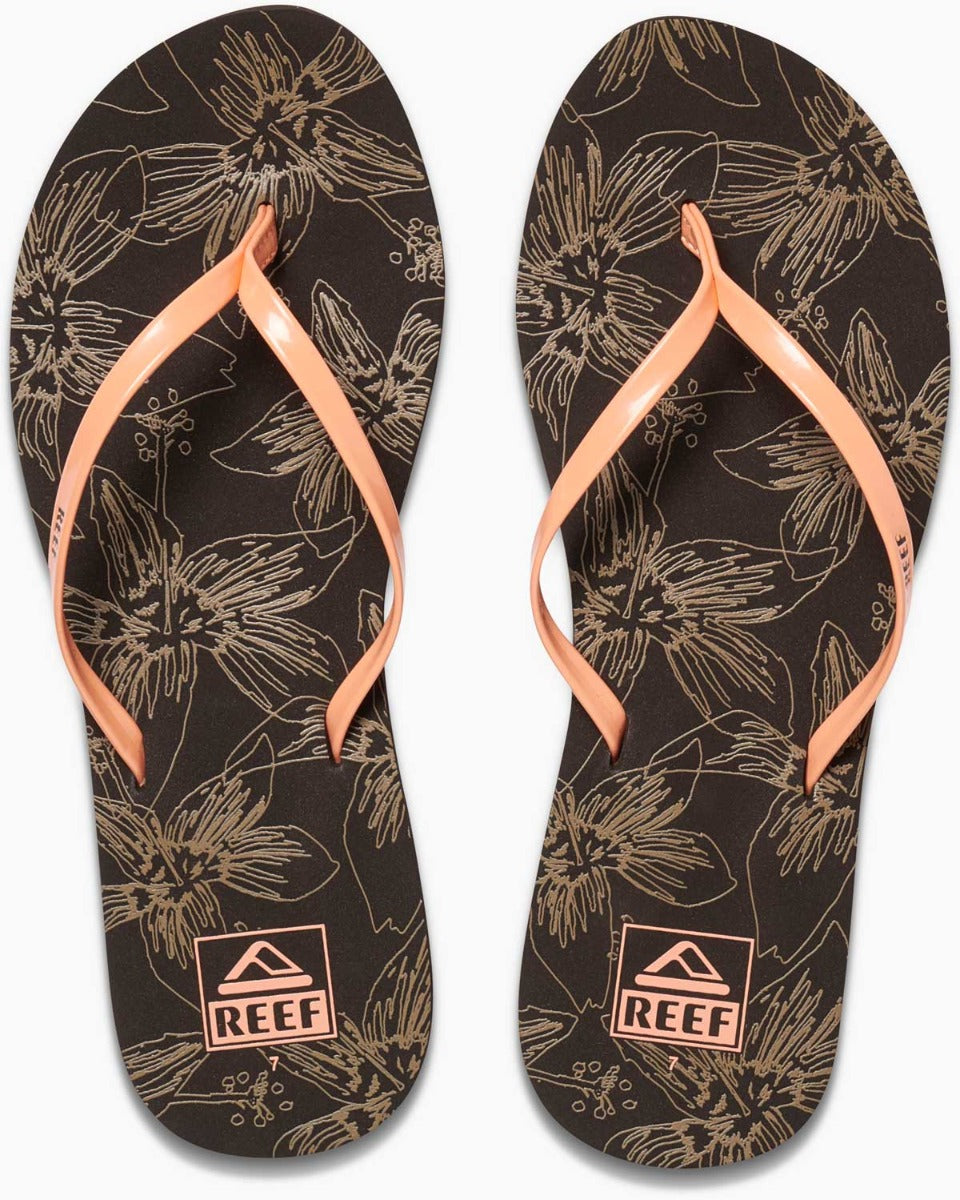 Reef Women's Bliss-Full Sandal - A pair of women's sandals with a floral pattern on a dark brown background, featuring light-colored flowers and leaves.