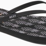 Reef Women's Bliss-Full Sandal 2020 - A pair of black sandals with a gold logo on the strap.