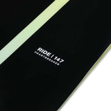 Ride Women's Heartbreaker Snowboard 2024 - A black snowboard with a light green stripe down the middle and silver screws along the top edge.