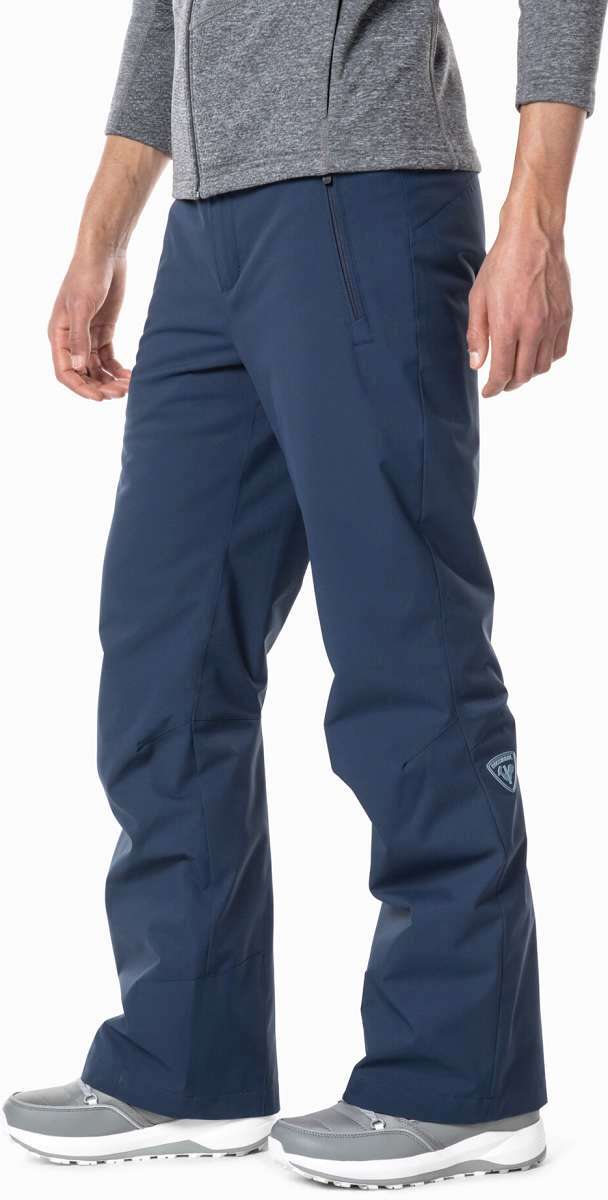 Rossignol Siz Insulated Pant 2024 - A pair of navy blue snow pants with a zippered pocket on the side and a logo patch near the bottom hem.
