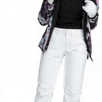 Roxy Junior's Backyard Insulated Pant 2024 - A pair of snow pants with a floral pattern in shades of purple and grey, featuring a fur-lined hood.