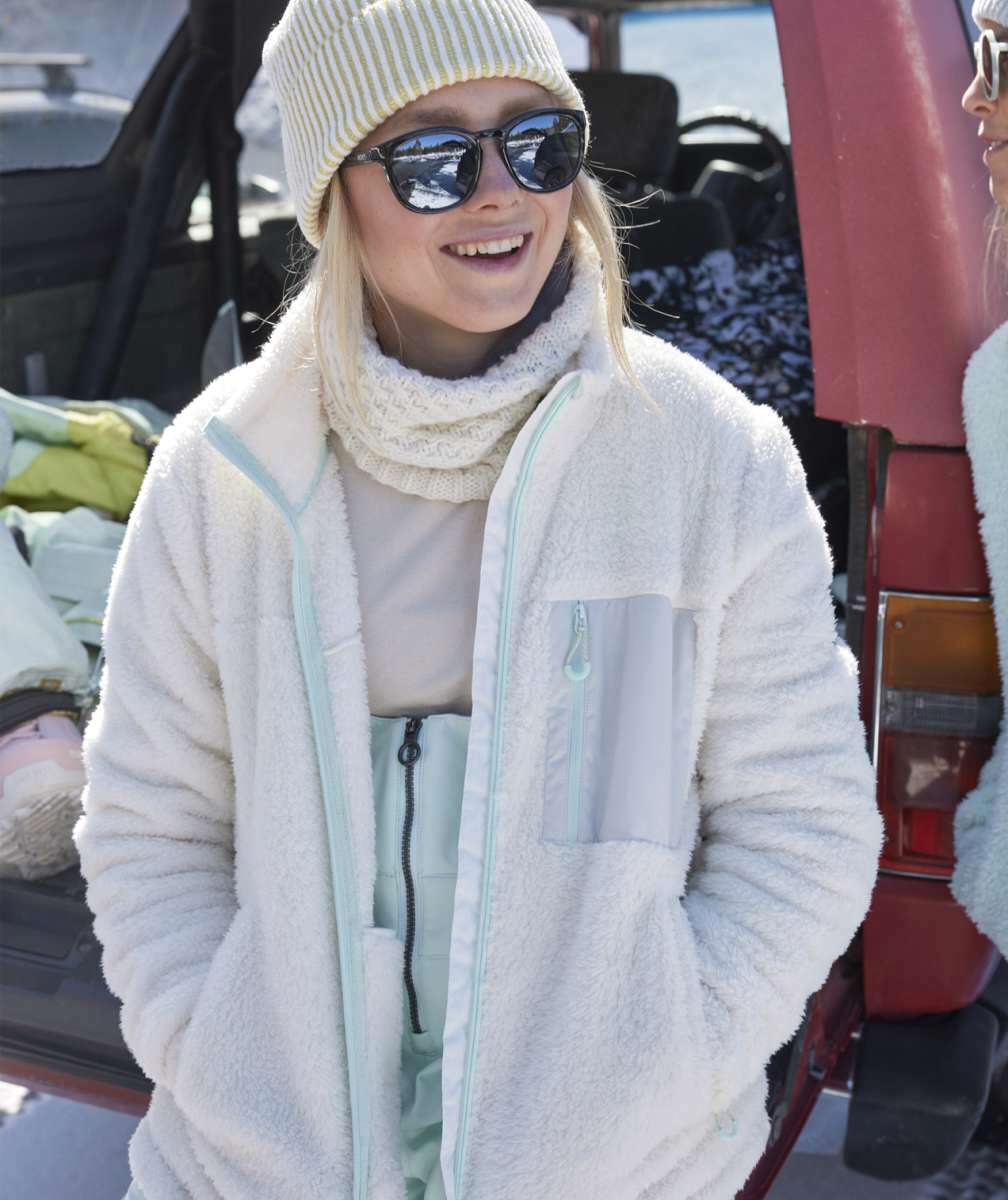 Roxy Women's Alabama Full Zip Jacket 2023 - A cream-colored jacket with a zippered front and two pockets on either side, worn by a model in front of a snowy background.