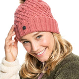 Roxy Women's Blizzard Beanie 2022 - A dusty rose-colored beanie with a ribbed pattern and a brown faux fur pom-pom on top.