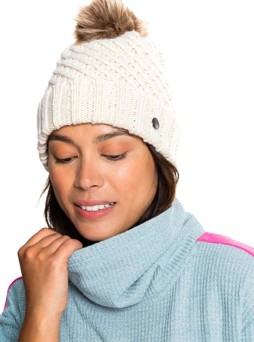 Roxy Women's Blizzard Beanie - A cream-colored beanie with a brown faux fur pom-pom on top.