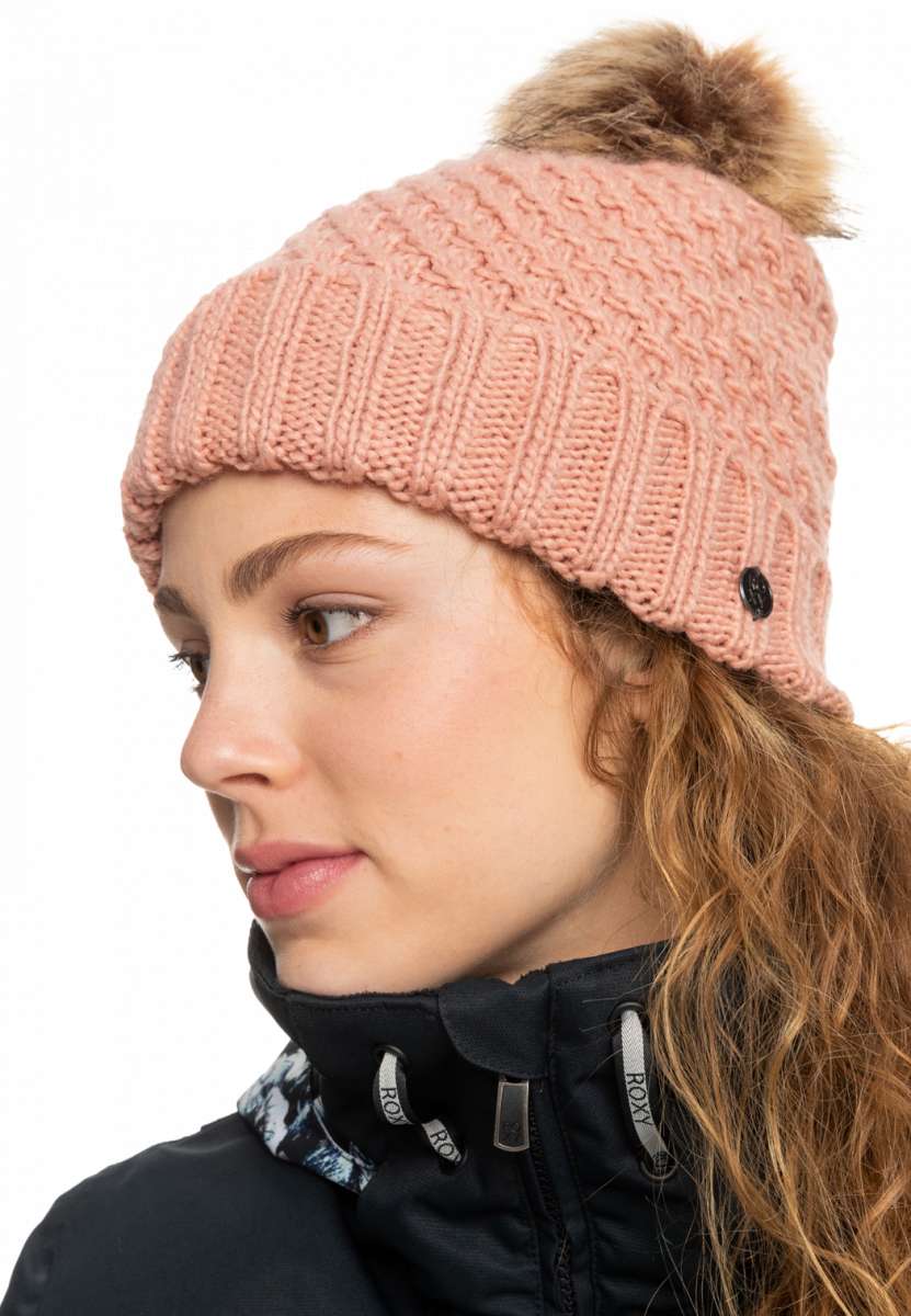 Roxy Women's Blizzard Beanie 2023 - A dusty rose-colored beanie with a ribbed pattern and a faux fur pom-pom on top.