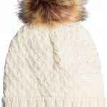 Roxy Women's Blizzard Beanie 2023 - A cream-colored beanie with a cable-knit pattern and a large, fluffy brown faux fur pom-pom on top.