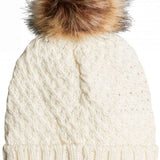 Roxy Women's Blizzard Beanie 2023 - A cream-colored beanie with a cable-knit pattern and a large, fluffy brown faux fur pom-pom on top.