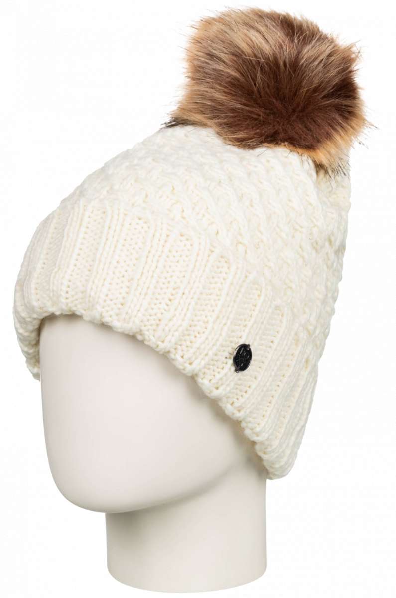 Roxy Women's Blizzard Beanie 2023 - A cream-colored beanie with a cable-knit pattern and a brown faux fur pom-pom on top.
