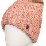 Roxy Women's Blizzard Beanie 2023 - A pink beanie with a cable-knit pattern and a brown faux fur pom-pom on top.