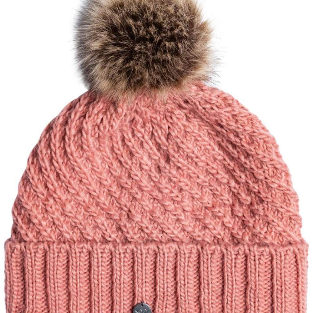 Roxy Women's Blizzard Beanie 2024 - A dusty rose-colored beanie with a cable-knit pattern and a large, fluffy brown faux fur pom-pom on top.