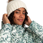 Roxy Women's Blizzard Beanie 2024 - A cream-colored beanie with a ribbed pattern and a brown faux fur pom-pom on top.