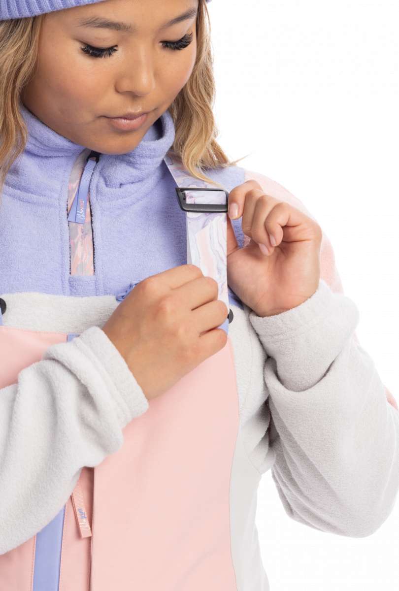 Roxy Women's Chloe Kim Bib Pant 2023 - A pair of snow pants with a black and white patterned design on the side, featuring a zippered pocket at the thigh.