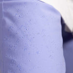 Roxy Women's Chloe Kim Insulated Pant 2023 - Water droplets on a pair of light purple snow pants with a subtle pattern.