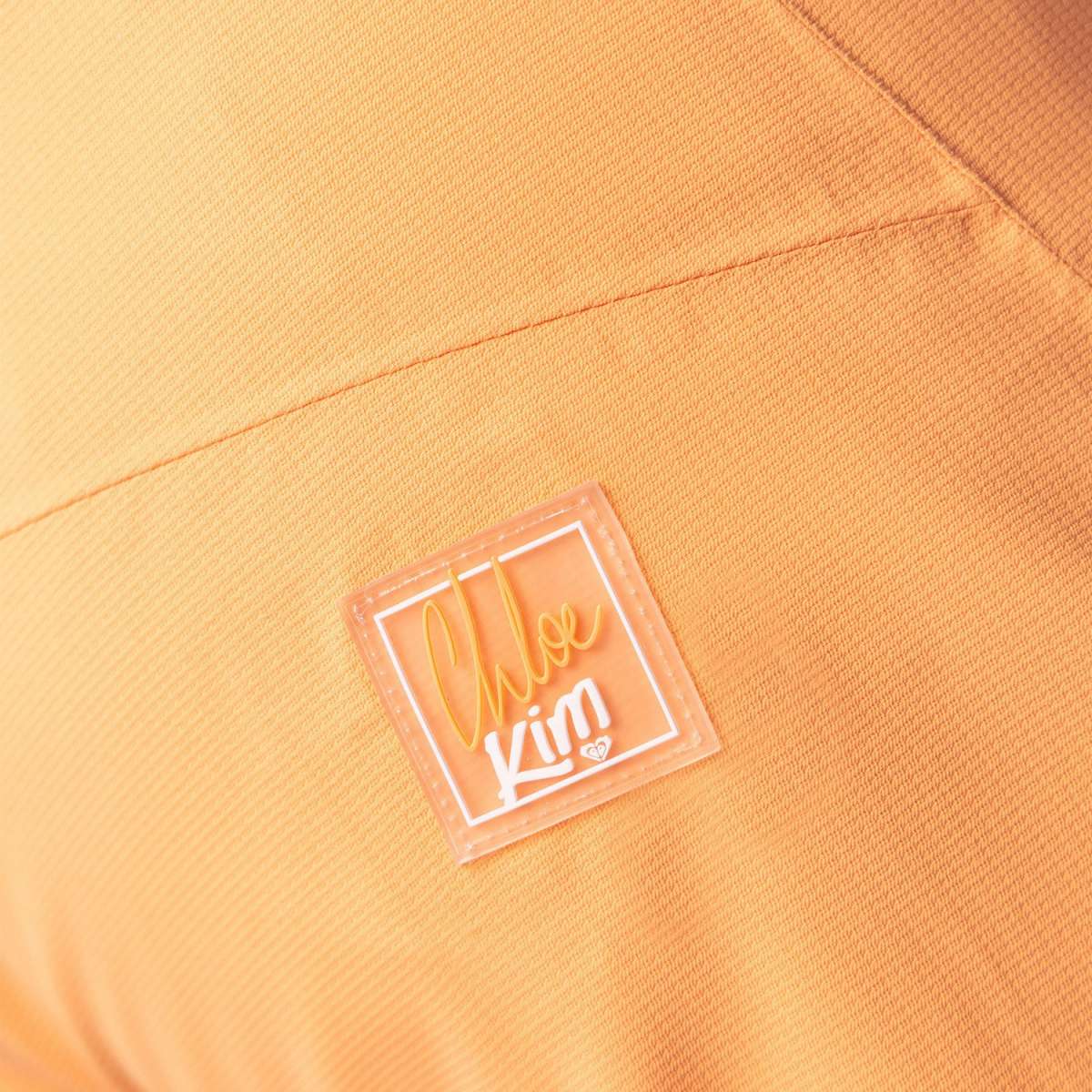 Roxy Women's Chloe Kim Woodrose Pant 2024 - A pair of light orange snow pants with a subtle floral pattern and white accents.