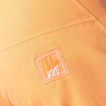 Roxy Women's Chloe Kim Woodrose Pant 2024 - A pair of light orange snow pants with a subtle floral pattern and white accents.