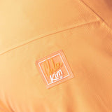 Roxy Women's Chloe Kim Woodrose Pant 2024 - A pair of light orange snow pants with a subtle floral pattern and white accents.