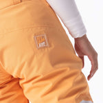 Roxy Women's Chloe Kim Woodrose Pant 2024 - A pair of women's snow pants in a woodrose color with a white logo on the left thigh that says "Chloe Kim" in cursive above "Kim" in block letters.