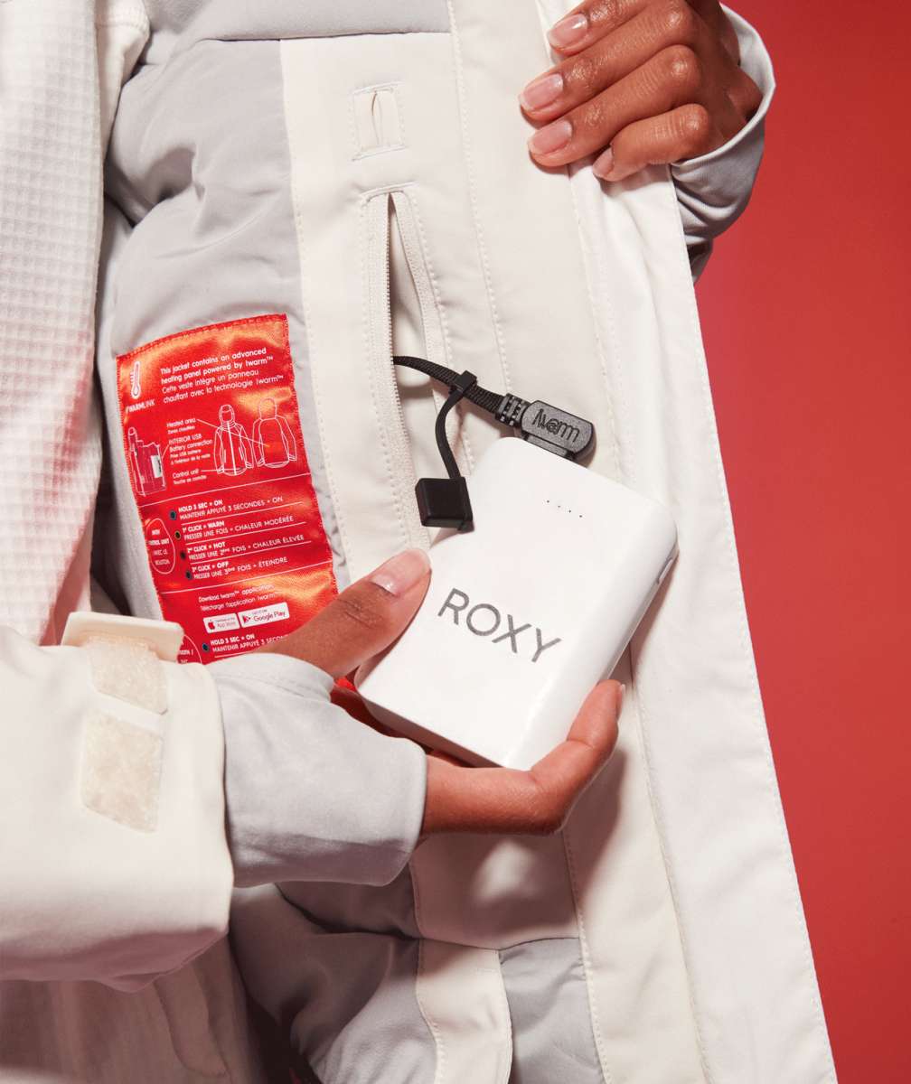 Roxy Women's Dusk Warmlink Insulated Jacket - White jacket with red lining and black zipper on front, held by a woman in white snow pants.