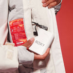 Roxy Women's Dusk Warmlink Insulated Jacket - White jacket with red lining and black zipper on front, held by a woman in white snow pants.