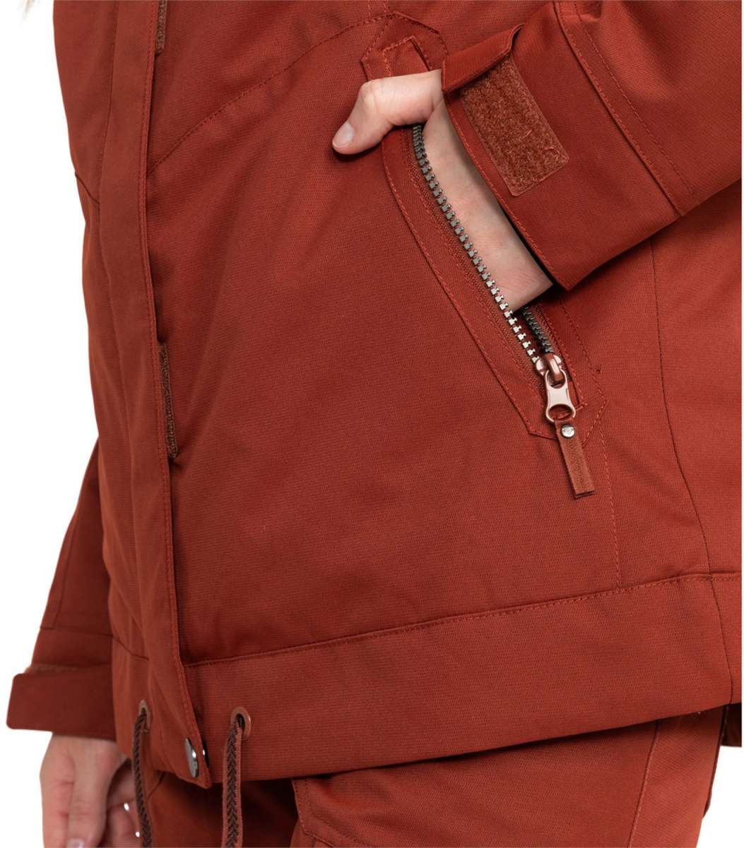Roxy Women's Meade Insulated Jacket - A rust-colored jacket with a zippered pocket on the left side and a brown zipper pull.