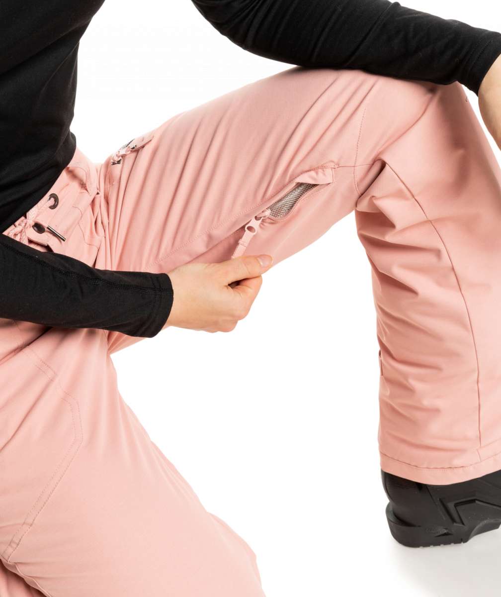 Roxy Women's Nadia Insulated Pant 2023 - A pair of pink snow pants with a zippered pocket on the right thigh and black drawstrings at the waist.