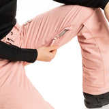 Roxy Women's Nadia Insulated Pant 2023 - A pair of pink snow pants with a zippered pocket on the right thigh and black drawstrings at the waist.