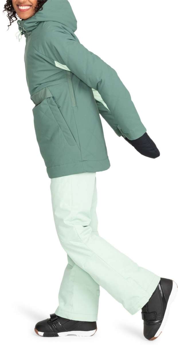 Roxy Women's Radiant Lines Pullover Jacket - A sage green jacket with a hood and white accents on the side, worn by a model who is posing sideways.