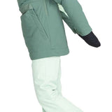 Roxy Women's Radiant Lines Pullover Jacket - A sage green jacket with a hood and white accents on the side, worn by a model who is posing sideways.