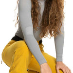 Roxy Women's Rising High Pant 2023 - A pair of yellow snow pants with a black waistband and zipper fly, featuring a zippered pocket on one thigh.